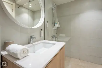 a white bathroom with a sink and a mirror at Belgrade Waterfront Luxury Studio in Belgrade