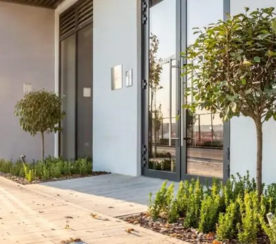 a building with glass doors and a tree in front of it at Belgrade Waterfront Luxury Studio in Belgrade