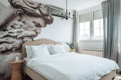 a bedroom with a large bed with a bust on the wall at Zeus Nest Apartment in Belgrade