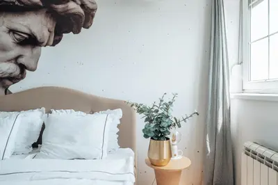 a bed with white sheets and a vase with a plant at Zeus Nest Apartment in Belgrade