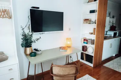 a room with a desk with a tv on a wall at Zeus Nest Apartment in Belgrade