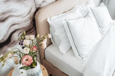 a white couch with pillows and a vase of flowers on a table at Zeus Nest Apartment in Belgrade
