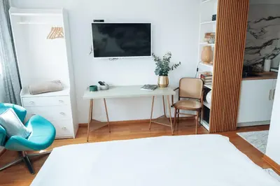 a bedroom with a desk and a tv and a chair at Zeus Nest Apartment in Belgrade