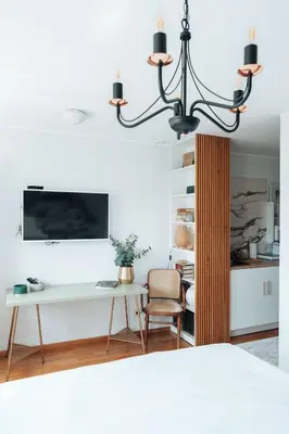 a living room with a desk and a chandelier at Zeus Nest Apartment in Belgrade