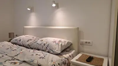 a bed with two pillows and a remote control on it at Aurora in Belgrade