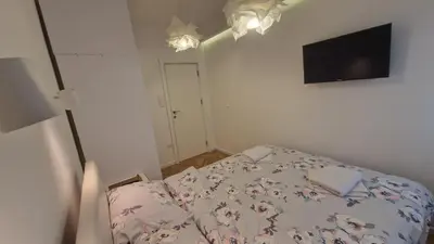 a bedroom with a bed and a flat screen tv at Aurora in Belgrade