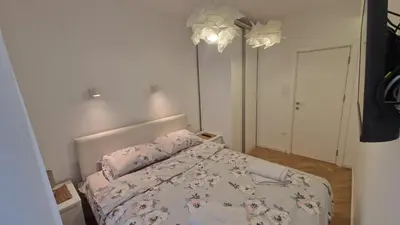 a small bedroom with a bed with a floral bedspread at Aurora in Belgrade