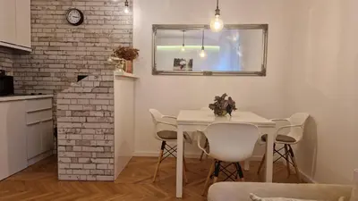 a kitchen and dining room with a white table and chairs at Aurora in Belgrade