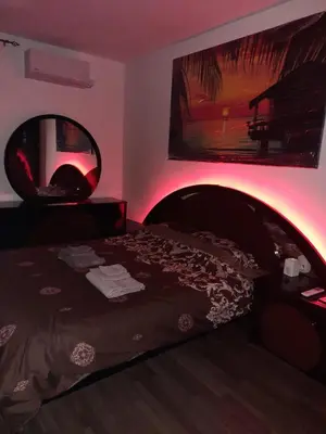 a bedroom with a bed with a red lighting at Dorcol Sunset Apartment in Belgrade