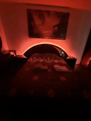 a dark room with a bed with red lights at Dorcol Sunset Apartment in Belgrade