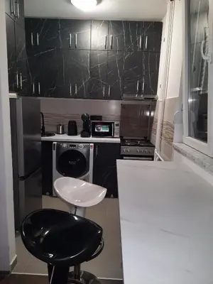 a black and white kitchen with a stool in it at Dorcol Sunset Apartment in Belgrade