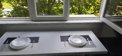 a table with two plates and utensils and a window at Dorcol Sunset Apartment in Belgrade