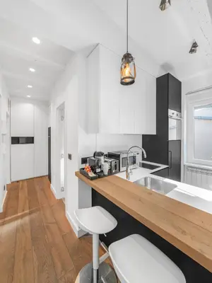 a kitchen with white cabinets and a wooden counter top at Enjoy B-52 Studio in Belgrade