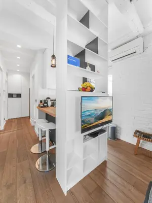 a living room with white walls and a flat screen tv at Enjoy B-52 Studio in Belgrade