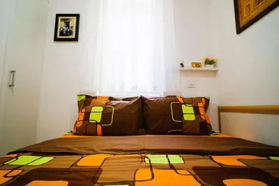 a bedroom with a bed with an orange and green quilt at Golden Place Belgrade in Belgrade