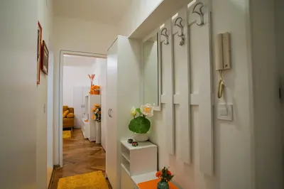 a hallway with white cabinets and a vase of flowers at Golden Place Belgrade in Belgrade