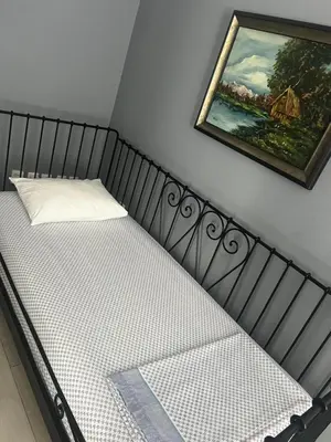 a bed in a room with a painting on the wall at Sandra City Center Apartment in Belgrade