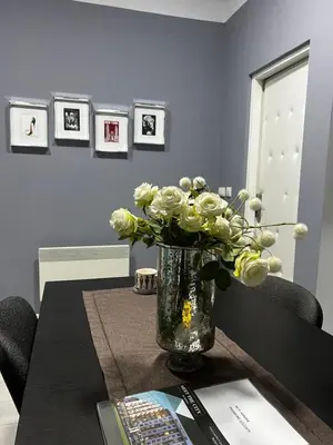 a vase filled with white flowers on a table at Sandra City Center Apartment in Belgrade