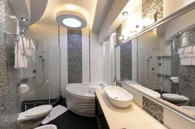 a bathroom with two toilets and a sink and mirrors at Hotel Majdan in Belgrade