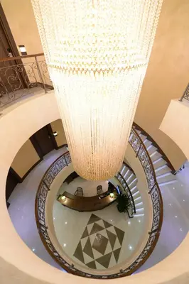 a large chandelier in a building with a spiral staircase at Hotel Majdan in Belgrade