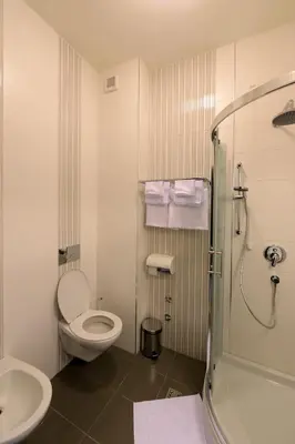 a bathroom with a toilet and a sink and a shower at Hotel Majdan in Belgrade