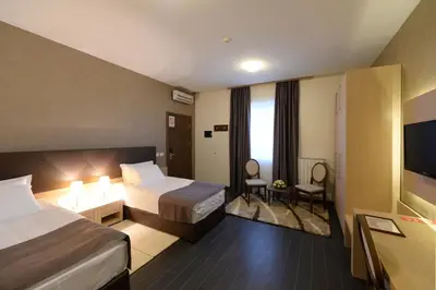 a hotel room with two beds and a television at Hotel Majdan in Belgrade