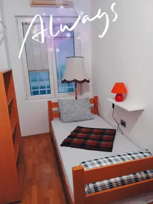 a small bedroom with two beds and a lamp at Jasmin in Belgrade