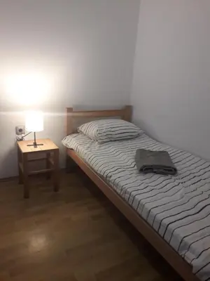 a bedroom with a bed and a table with a lamp at Jasmin in Belgrade