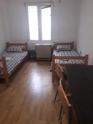 a room with two beds and a table at Jasmin in Belgrade