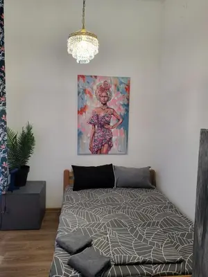 a bedroom with a bed and a painting on the wall at JASMIN suites in Belgrade