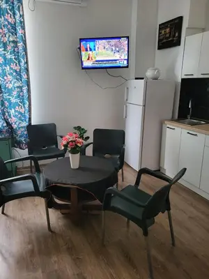 a room with a table and chairs and a tv at JASMIN suites in Belgrade