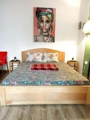 a bedroom with a bed with a painting on the wall at JASMIN suites in Belgrade