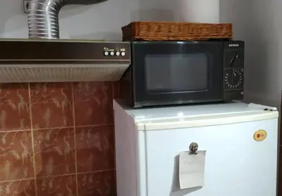 a microwave sitting on top of a refrigerator at Apartman Oaza Olja in Belgrade