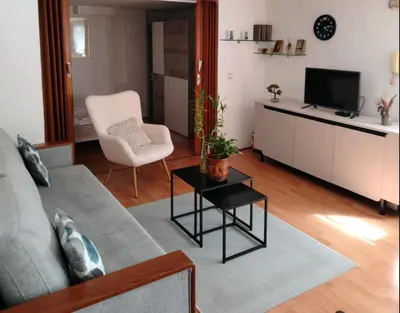 a living room with a couch and a tv and a chair at Apartman Oaza Olja in Belgrade