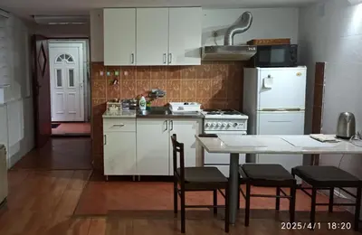 a kitchen with white cabinets and a table with chairs at Apartman Oaza Olja in Belgrade
