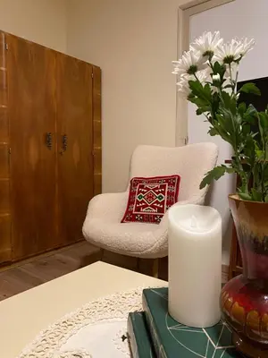 a living room with a chair and a vase with flowers at Bukovički mir in Arandjelovac
