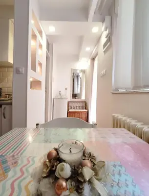 a table with a bowl and flowers on it at Ada Belgrade Apartment in Belgrade