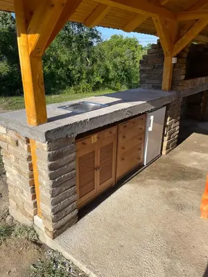 an outdoor kitchen with a stone counter top at Deda Momirov zavičaj in Tulež