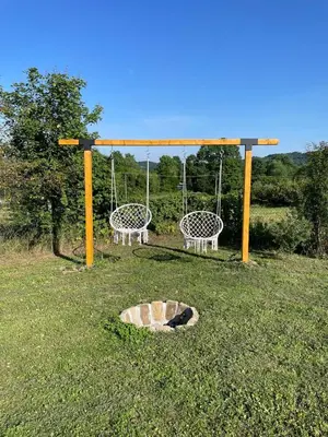 a park with two swings and a fire pit at Deda Momirov zavičaj in Tulež