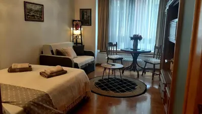 a bedroom with a bed and a living room with a couch at Modern Lux Studio w Inside parking 5 min from Skadarlija, Republic Sqre in Belgrade