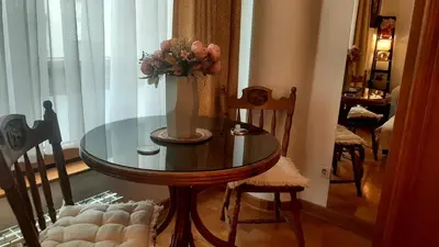 a dining room table with a vase of flowers on it at Modern Lux Studio w Inside parking 5 min from Skadarlija, Republic Sqre in Belgrade