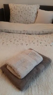 a white towel sitting on a bed with a blanket at Modern Lux Studio w Inside parking 5 min from Skadarlija, Republic Sqre in Belgrade