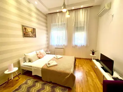 a bedroom with a bed and a flat screen tv at DORA stan na dan Novi Beograd Savada Blok A, parking 5 evra dan in Belgrade