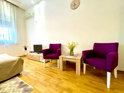 two purple chairs and a table in a room at DORA stan na dan Novi Beograd Savada Blok A, parking 5 evra dan in Belgrade
