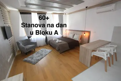 a living room with a bed and a table at DORA stan na dan Novi Beograd Savada Blok A, parking 5 evra dan in Belgrade
