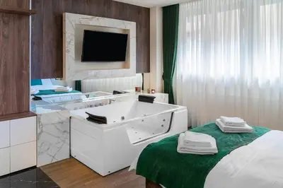 a hotel room with a bath tub and a tv at 9 Nine - Luxury Apartments & Suites in Belgrade