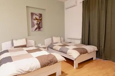 two beds sitting next to each other in a bedroom at AirMi hotel in Surčin