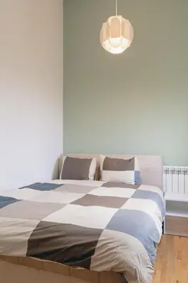 a bedroom with a bed with a checkered blanket at AirMi hotel in Surčin