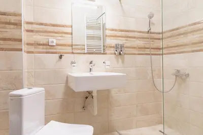 a bathroom with a toilet and a sink and a shower at AirMi hotel in Surčin