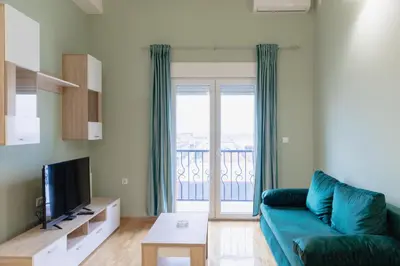 a living room with a blue couch and a balcony at AirMi hotel in Surčin